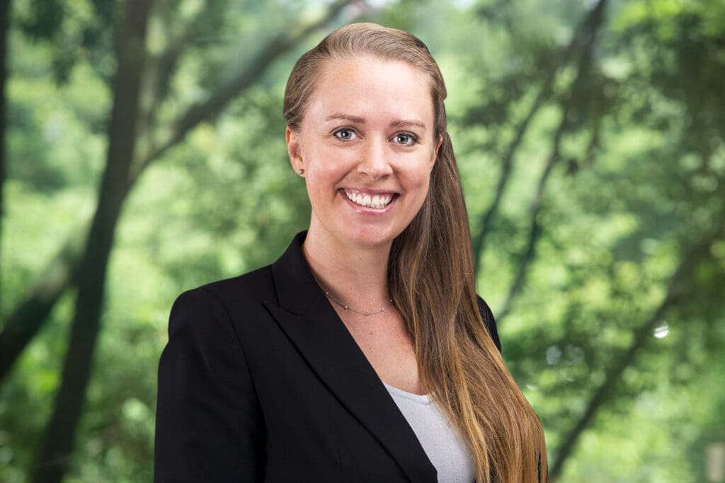 Smiling female attorney portrait in park setting, professional headshot for legal website