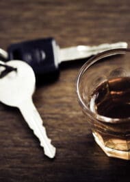 Car keys and whiskey glass, symbolizing drunk driving accidents handled by our law firm.