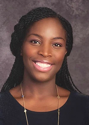 Smiling African American woman with braided hair wearing necklace, professional headshot