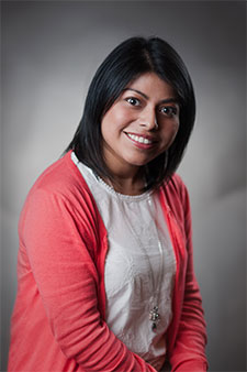 Smiling Hispanic woman in red cardigan, representing a welcoming and trustworthy legal professional.