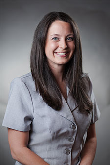 Friendly smiling female attorney in grey business suit, ready to provide legal assistance.