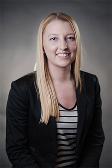 Professional headshot of a smiling blonde woman in a black jacket, suitable for an attorney website.