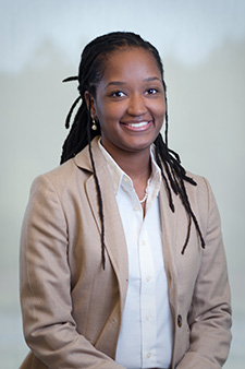 Smiling African American woman in brown blazer, approachable injury attorney ready to assist clients.