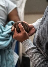 Compassionate hands clasped in support, symbolizing care and advocacy during difficult times.