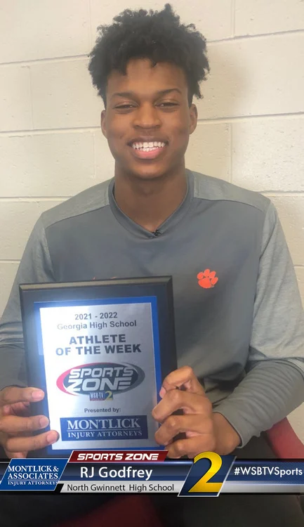 Smiling high school athlete of the week holding Sports Zone award, presented by injury attorneys