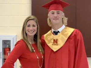 Smiling blonde woman in red shirt and blonde male graduate in red cap and gown, personal injury law
