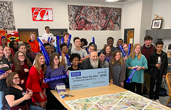 Group photo of diverse people holding oversized check donation for spinal cord injury charity.