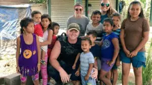 Group of smiling diverse children gathered with adults outdoors, appearing happy and healthy