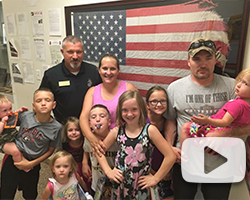 Happy family posing with American flag at office, smiling together after successful legal case.