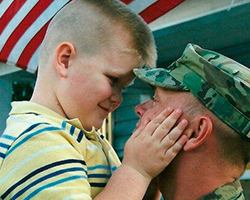Young boy cries near father's military hat, depicting the emotional impact of military injuries on families.
