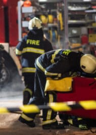 Firefighters at car crash scene with wrecked vehicles and caution tape. Injury attorney image.