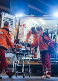 SEO-friendly alt text (98 characters): Emergency medical team treating patient on stretcher at night, rushing to ambulance