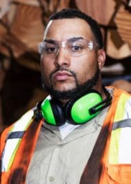Construction worker wearing safety gear, looking serious. Workplace injury concept for legal website.