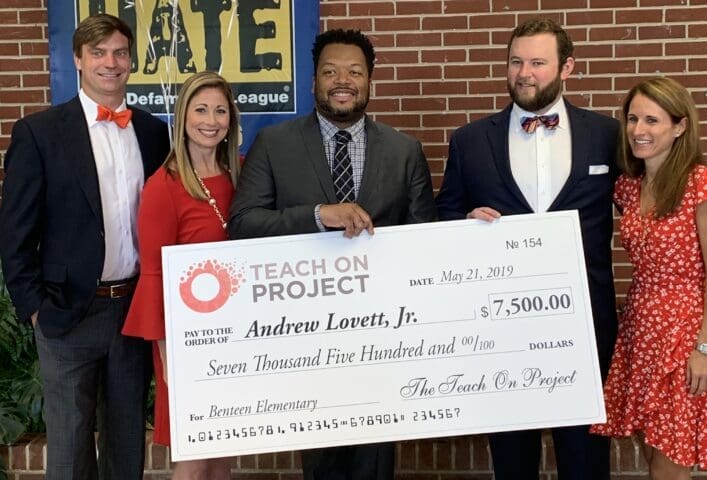 Group holding oversized check donation to Teach On Project at Benteen Elementary school.