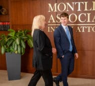 A smiling man in a suit shakes hands with a blonde woman in front of a sign reading "Montlick Associates Injury Attorneys".