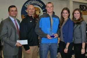 Award presented to man with blue jacket at Chattahoochee Police Dept, standing with four other people