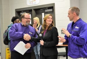 Adults shaking hands at lawyer's office after successful settlement, smiling gratefully