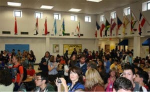 Crowded school event with diverse attendees and international flags, potential injury hazard