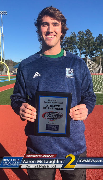 Denmark High School student athlete of the week Aaron McLaughlin holds award plaque on sports field