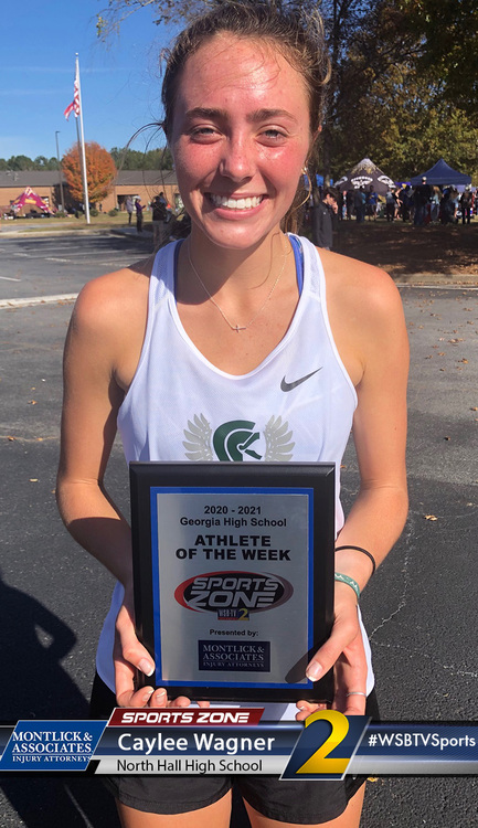 Athlete of the Week Caylee Wagner holding Sports Zone award plaque, smiling outdoors on school campus