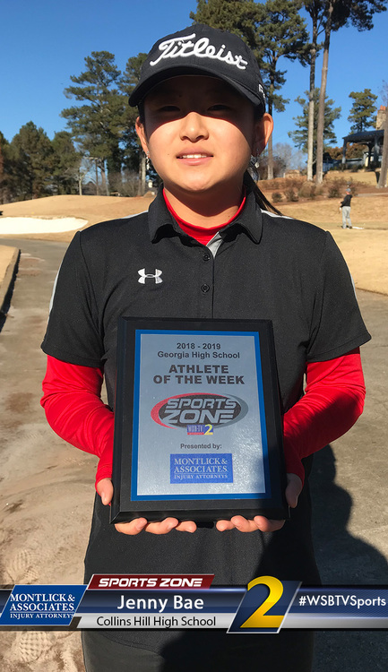 Young golfer proudly holds Athlete of the Week award from Collins Hill High School Sports Zone.