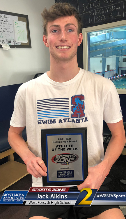 WSFHS Athlete of the Week proudly holds Sports Zone award at training facility, smiling confidently.