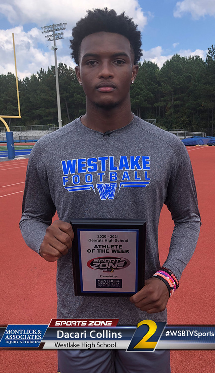 Young male athlete holding Athlete of the Week award on high school track, ready for sports competition