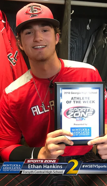 High school baseball player Ethan Hankins holds Sports Zone award for Athlete of the Week, smiling in uniform.