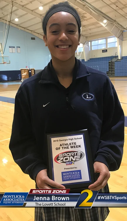 High school girl athlete of the week Jenna Brown smiling and holding award in gymnasium setting