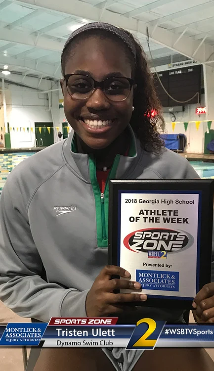 Smiling Georgia high school athlete of the week holding Sports Zone award, sponsored by injury attorneys