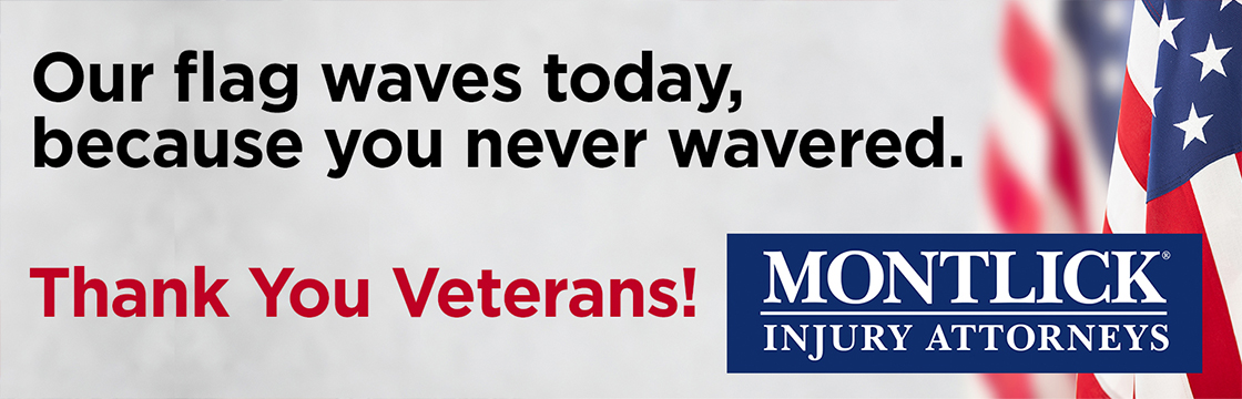 Alt text: American flag waving in wind for Veterans Day, thanking veterans from Montlick injury attorneys