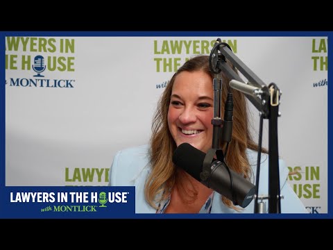 Young smiling woman speaking into microphone with "Lawyers in the House" banner in background, 90 characters, SEO-friendly alt text for an injury attorney website.