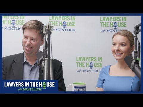Injury lawyer couple smiling at camera during TV interview about their practice, with logo backdrop