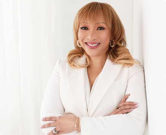 Smiling blonde woman in white blazer with arms crossed, professional headshot for attorney website