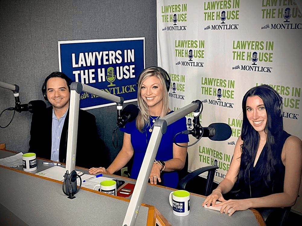 Three smiling attorneys, two women and one man, sitting at a radio station with "Lawyers in the House" banner backdrop.