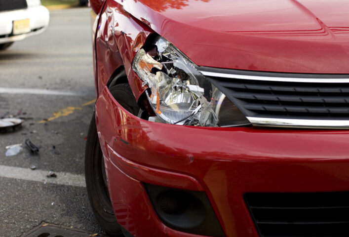 A red car with a damaged headlight after an accident Atlanta car accident lawyers