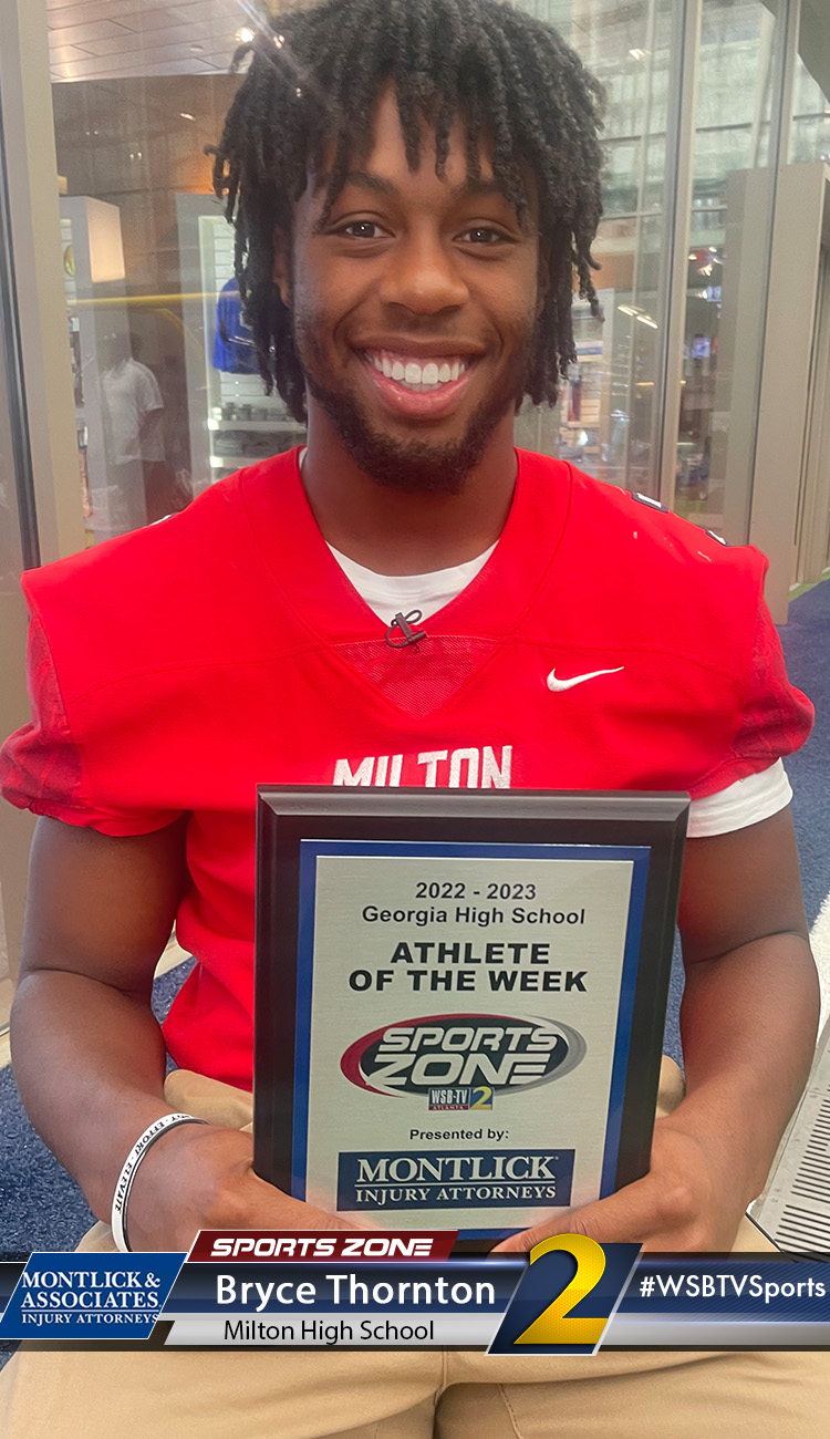 Smiling high school athlete holding Sports Zone Athlete of the Week award
