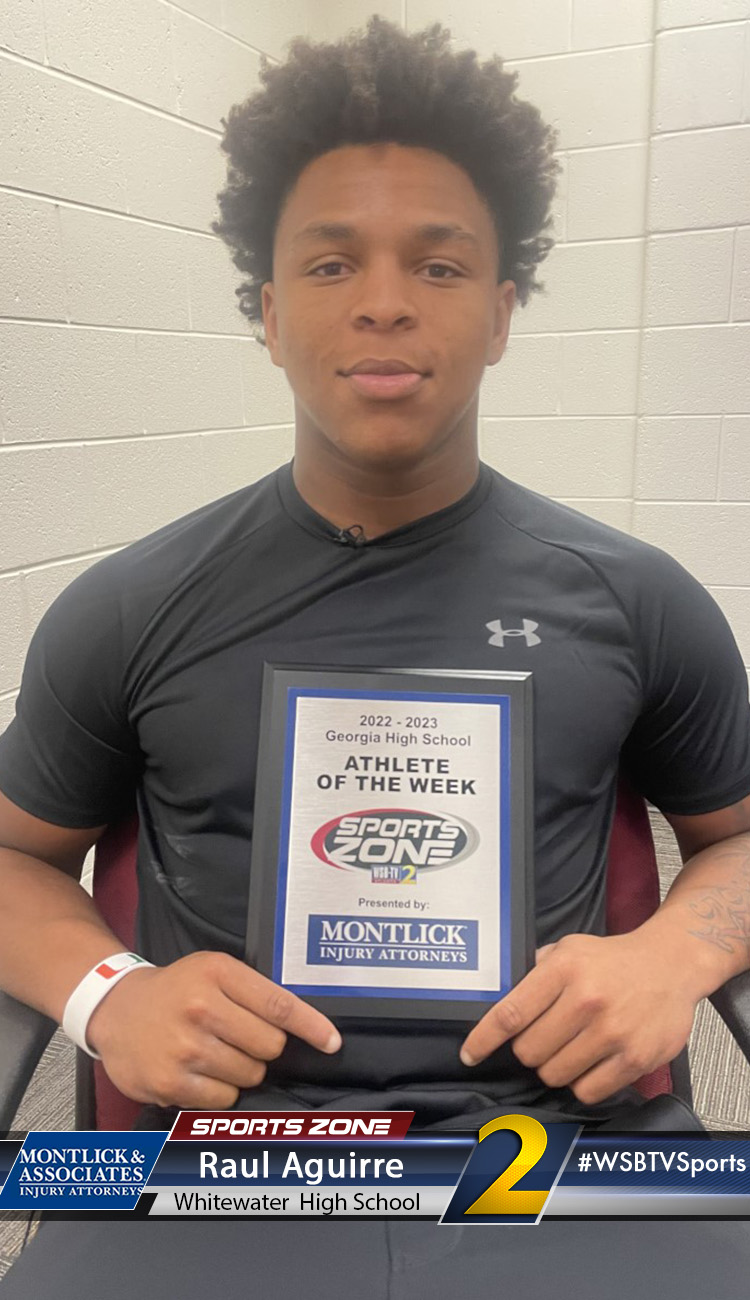 Smiling high school athlete holding Sports Zone Athlete of the Week award
