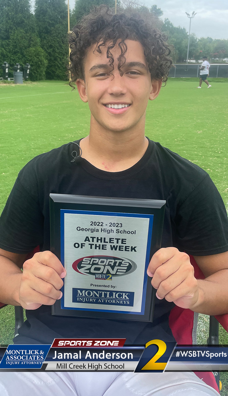 Smiling high school athlete holding Sports Zone Athlete of the Week award