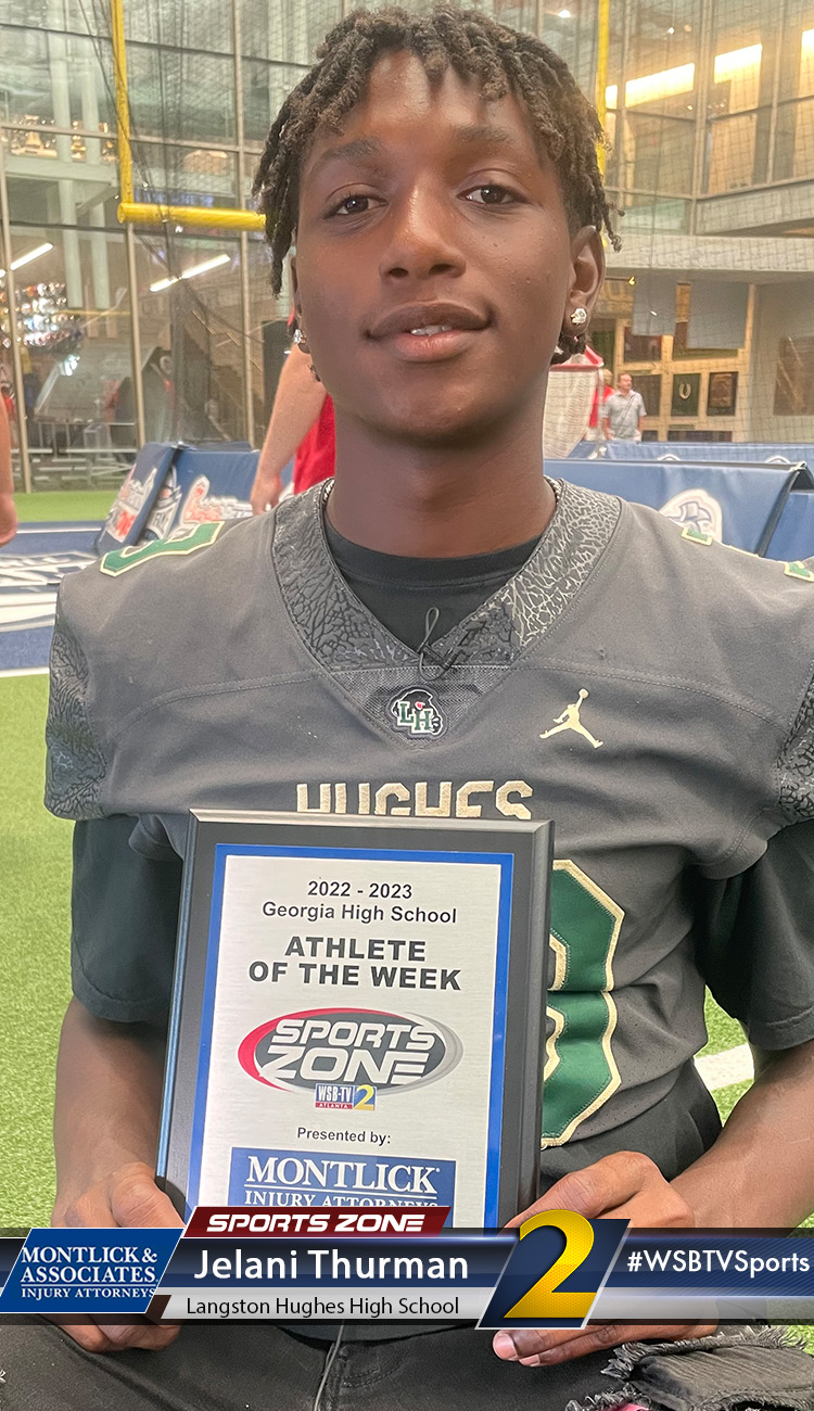 Smiling high school athlete holding Sports Zone Athlete of the Week award