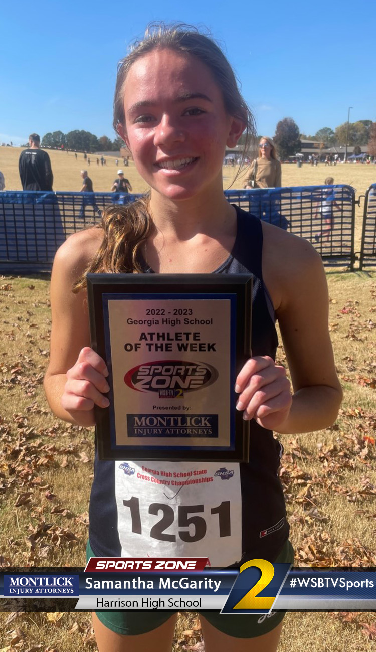 Smiling high school athlete holding Sports Zone Athlete of the Week award