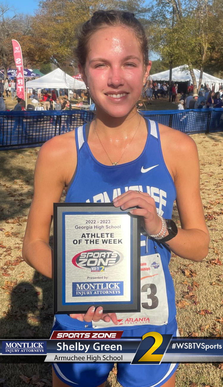 Smiling high school athlete holding Sports Zone Athlete of the Week award