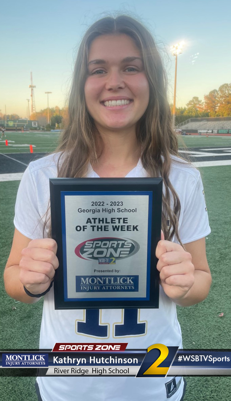 Smiling high school athlete holding Sports Zone Athlete of the Week award