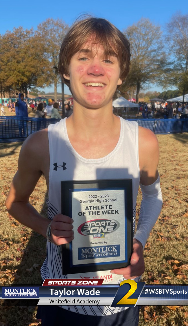Smiling high school athlete holding Sports Zone Athlete of the Week award
