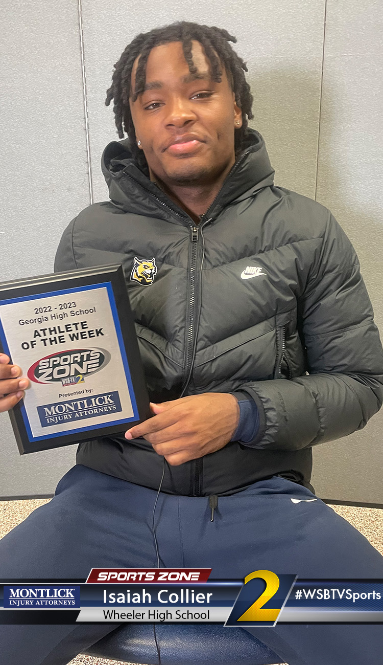 Smiling high school athlete holding Sports Zone Athlete of the Week award