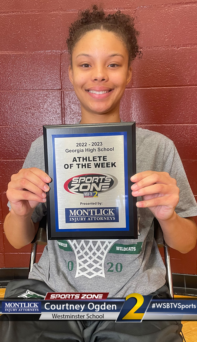 Smiling high school athlete holding Sports Zone Athlete of the Week award