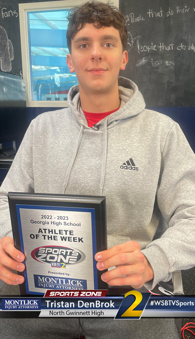 Smiling high school athlete holding Sports Zone Athlete of the Week award
