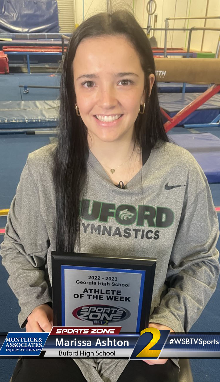 Smiling high school athlete holding Sports Zone Athlete of the Week award