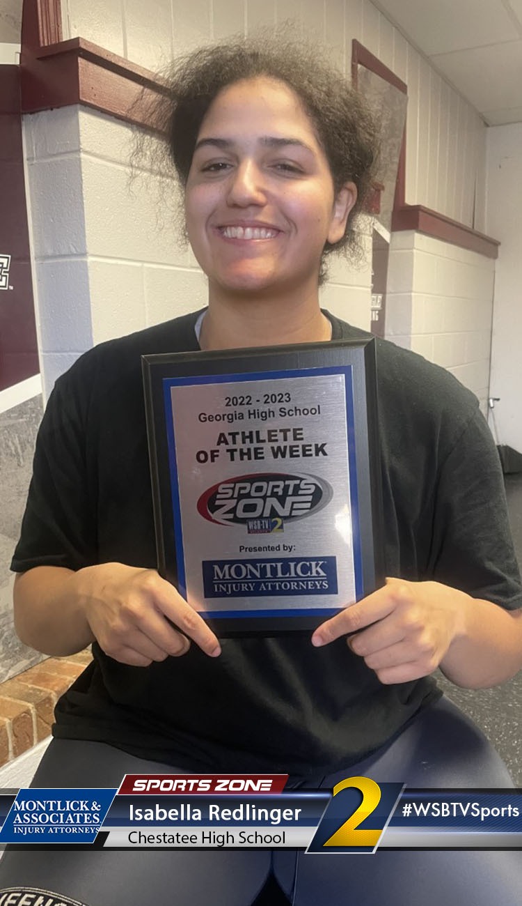 Smiling high school athlete holding Sports Zone Athlete of the Week award