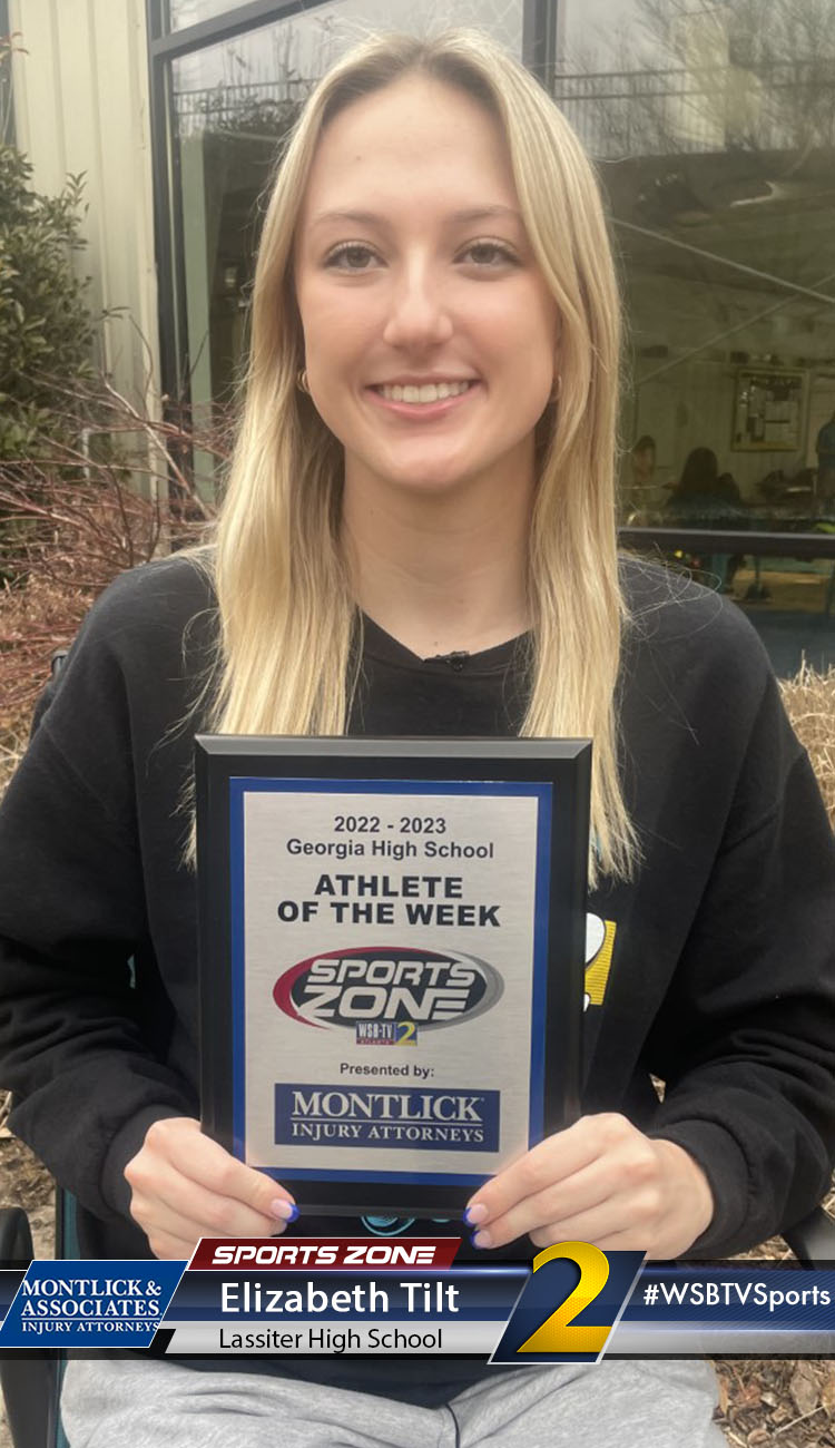 Smiling high school athlete holding Sports Zone Athlete of the Week award